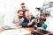 Three engineers print the details on the 3d printer. An elderly man controls the process. Two others follow the process.