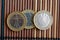 Three euro coins lie on wooden bamboo table in a row Denomination is 2 euro - back side