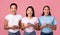 Three Excited Multiethnic Women Texting On Smartphones Over Pink Background