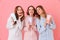 Three fascinating young girls 20s in colorful homewear smiling a