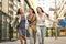 Three fashionable girls walking happy city after shopping.