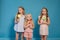 Three fashionable little girls eat candy lollipop