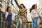 Three fashionable young women strolling with shopping bags.