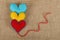 Three felt craft hearts, yellow, red and blue