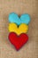 Three felt craft hearts, yellow, red and blue