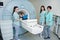 Three female doctors near magnetic resonance imaging machine with patient inside