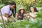 Three female farmers removing the weeds and laughing in an urban garden.