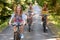 Three female friends riding bikes in park