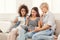 Three female friends using tablet and drinking coffee