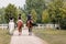 Three female riders riding horses side by side near wood fencing, rear view