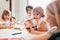 Three female siblings children indoor drawing on a paper