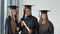 Three female students of different races with a diploma in hand. University female graduates with higher education