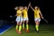 Three field hockey players celebrate the victory