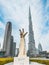 Three Fingers Statue in Burj Park surrounded by skyscrapers in Downtown Dubai, United Arab Emirates