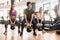 Three fit young people exercising kettlebell swings during full-