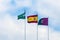 Three flags: Spain, Andolusia and Malaga against the blue sky with white clouds.