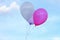 Three Floating balloons on the blue sky. pink balloon. purple balloon. violet balloon. white balloon.