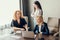 Three focused business women working together, brainstorming in office.