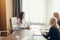 Three focused business women working together, brainstorming in office.