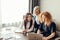 Three focused business women working together, brainstorming in office.