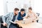 Three focused businesspeople working with laptop in office