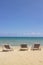 Three folding chairs on the beach with sea and bright sky in the background at Koh Mak in Trat, Thailand. Seasonal Vacation.