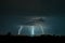 Three forked lightning bolts next to each other strike down to the earth near the city of Targu Mures, Romania.