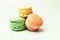 Three fresh colored macaroons lie in a heap in the center. Meringue on an isolated background with copy space