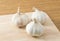 Three Fresh Garlic Bulbs on Wooden Cutting Board