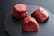 Three fresh raw Prime Black Angus beef steaks on stone background