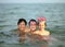 Three friendly brothers swimming in the sea