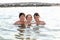 Three friendly brothers swimming in the sea during summer vacati