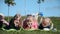 Three friendly sisters lie in the park on the grass and smile