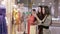 Three friendly women discussing dresses in the shop-window