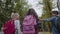 Three Friends With Backpacks Are Going to School. Back View of Mixed Racial Group of School Kids Walking Down the Street