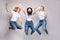 Three friends in casual clothes dancing and jumping. Different, but beautiful ladies in jeans and white T-shirts getting