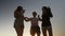 Three friends dancing on a beach at sunset