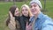 Three friends, do selfie for a walk in the park. Blonde, brunette and a young man. Have fun and enjoy life