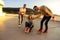 Three friends fooling around with skateboard on the top roof at