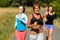 Three friends running outdoors smiling