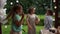 Three friends of schoolchildren are dancing at a birthday party. there is a birthday table with cake and pastries nearby