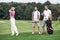 Three friends spending good time at the field playing golf and watching the shot