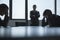 Three frustrated and overworked business people in the board room with arms crossed and head in hands.