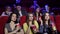 Three frustrated young girls watching an uninteresting movie at the cinema.