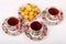 Three full porcelain teacups with hot tea and with floral pattern and plate with wild apricots