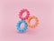 Three gear wheels isolated on pastel pink background. minimal teamwork concept. 3d rendering