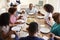 Three generation African American  family holding hands and saying grace at table before dinner,elevated view