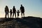 Three generation family on a beach holding hands, admiring view, full length, silhouette, back view