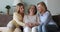 Three generation women having pleasant conversation seated on sofa