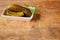 Three gherkins in bowl over wood